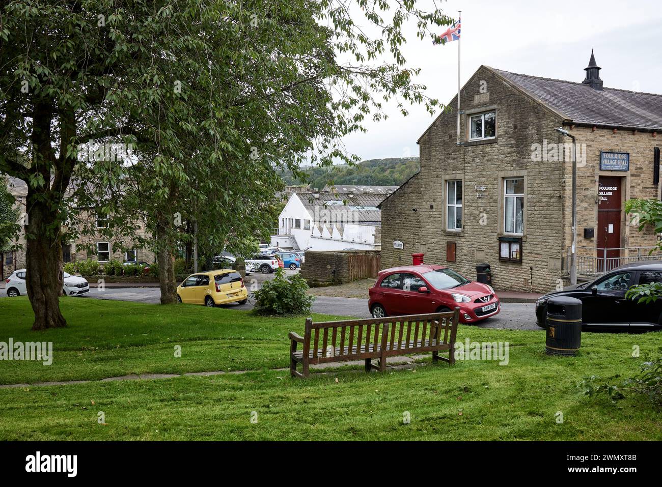 A settembre, una vista sul verde del villaggio verso una fabbrica industriale a Foulridge, Lancashire. Foto Stock
