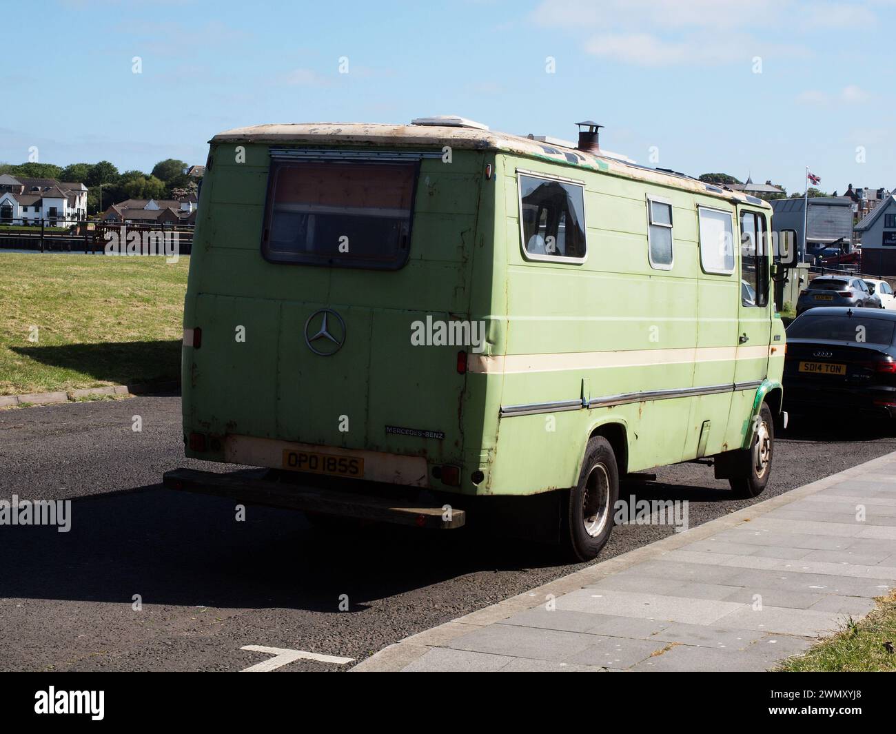 Un camper 'Mercedes Benz 608D' verde lime del 1977 con una caratteristica pila di fumo che sporge attraverso il tetto del veicolo. Foto Stock
