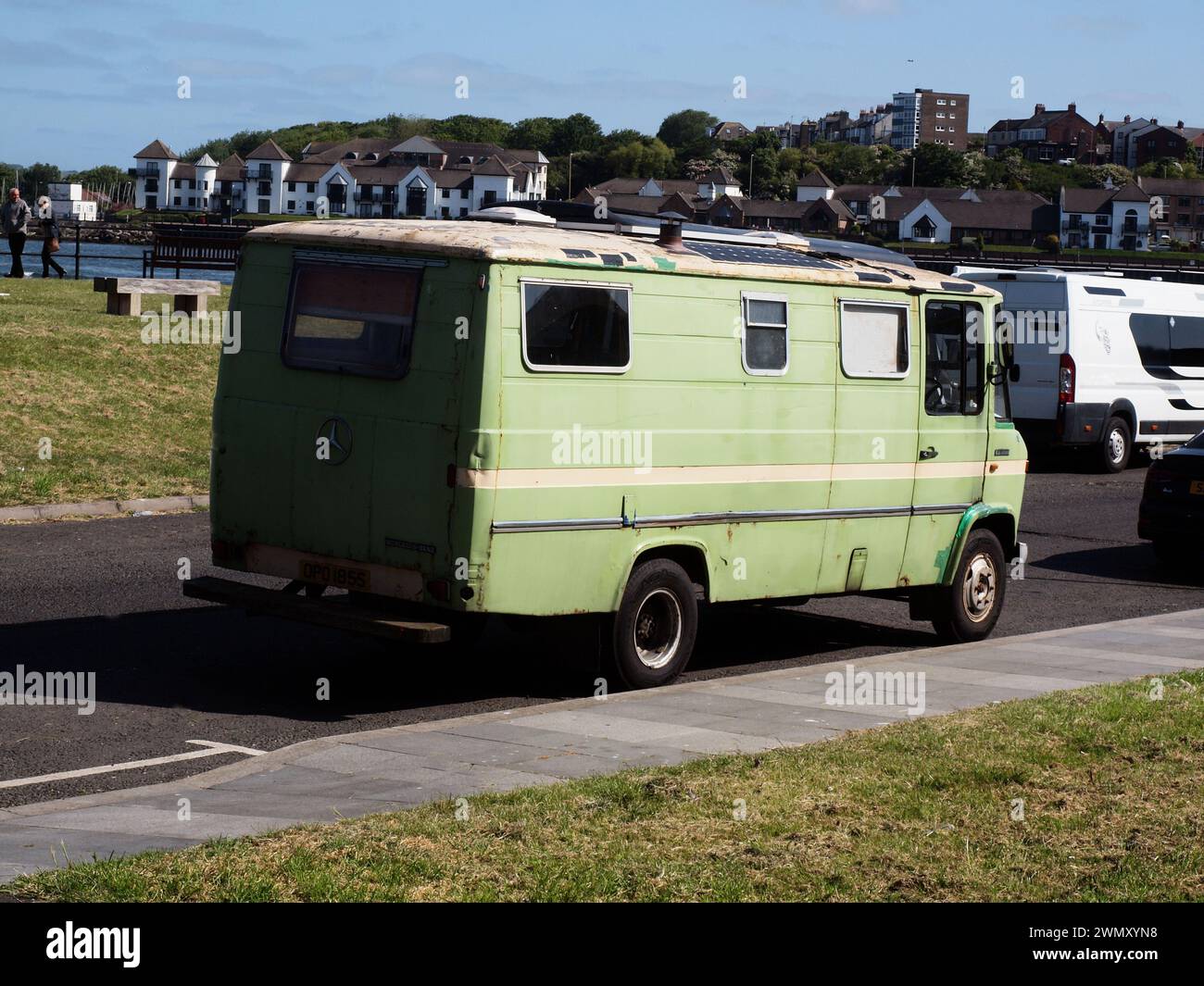 Un camper 'Mercedes Benz 608D' verde lime del 1977 con una caratteristica pila di fumo che sporge attraverso il tetto del veicolo. Foto Stock