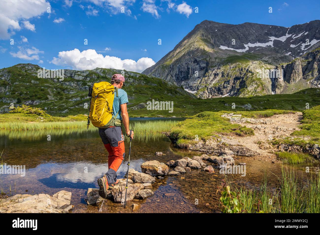 Francia, Isère, Matheysine, massiccio di Taillefer, Lago Fourchu (2053 m) presso la Chemin de grande Randonnée GR 50, escursionista su un piccolo guado Foto Stock