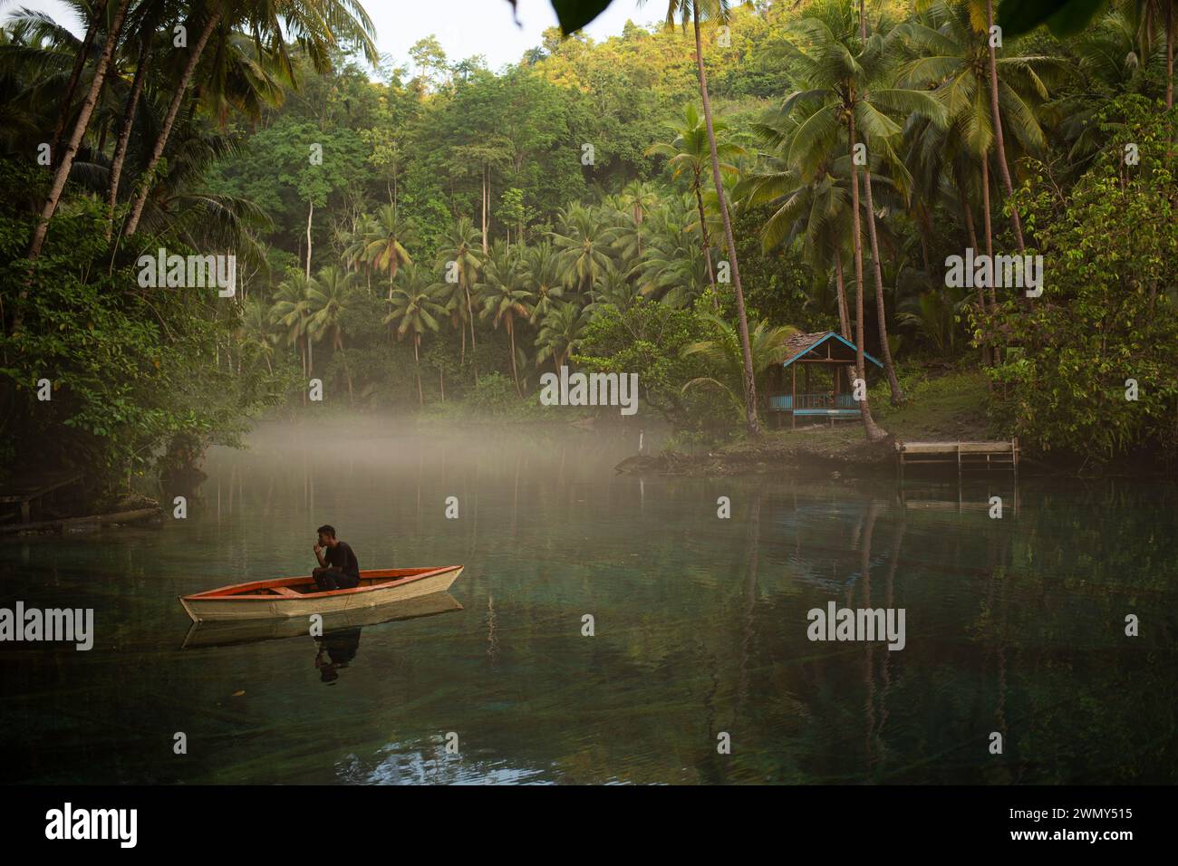 Un uomo in barca al lago Paisu Pok a Luk Panenteng, Banggai, Sulawesi, Indonesia. Foto Stock