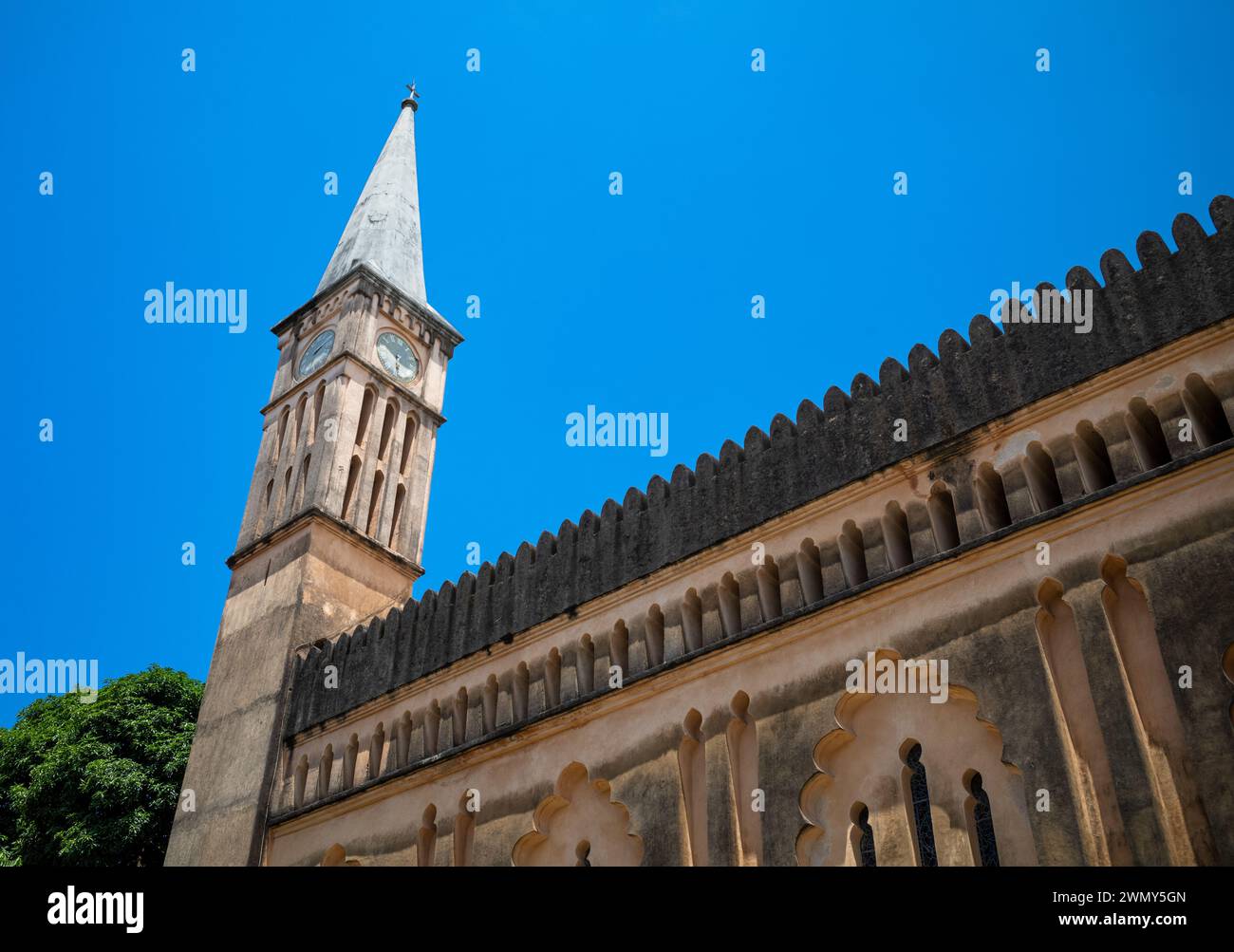 Una torre e una guglia con orologio nella Christ Church Cathedral, una chiesa anglicana, a Stone Town, Zanzibar, Tanzania Foto Stock