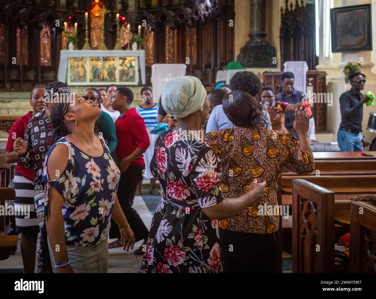 Le adoratrici cantano, ballano e pregano di domenica all'interno della cattedrale anglicana Christ Church di Stone Town, Zanzibar, Tanzania Foto Stock