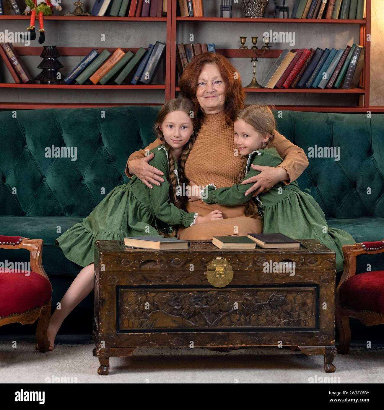 Felice nonna e nipoti leggono libri insieme e si divertono a casa Foto Stock