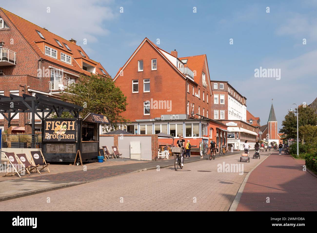 Persone che viaggiano in bicicletta in strada nella città sull'isola della Frisia orientale Juist, bassa Sassonia, Germania Foto Stock