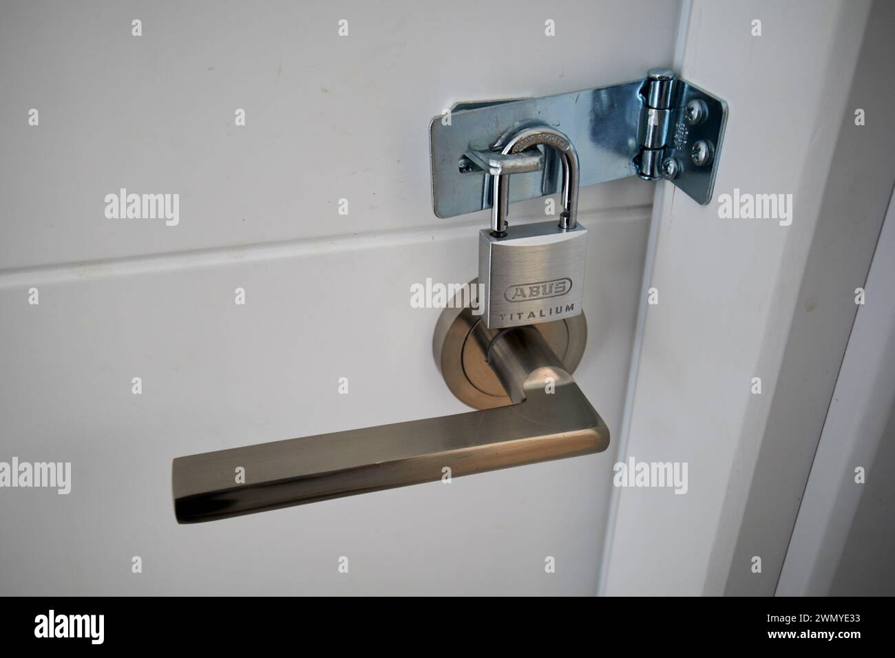 lucchetto su una fibbia e graffa su una porta che la blocca dall'esterno della spagna Foto Stock