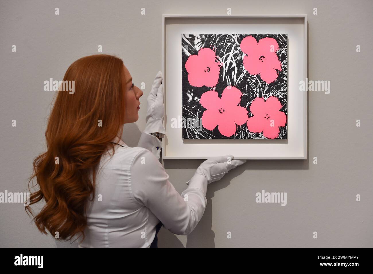 Londra, Inghilterra, Regno Unito. 28 febbraio 2024. Il membro dello staff di Sotheby detiene Andy Warhol's.'Flowers' stimato a 500.000 - 700.000 GBP durante l'anteprima delle prime aste di arte moderna e contemporanea di Sotheby del 2024. (Credit Image: © Thomas Krych/ZUMA Press Wire) SOLO PER USO EDITORIALE! Non per USO commerciale! Foto Stock