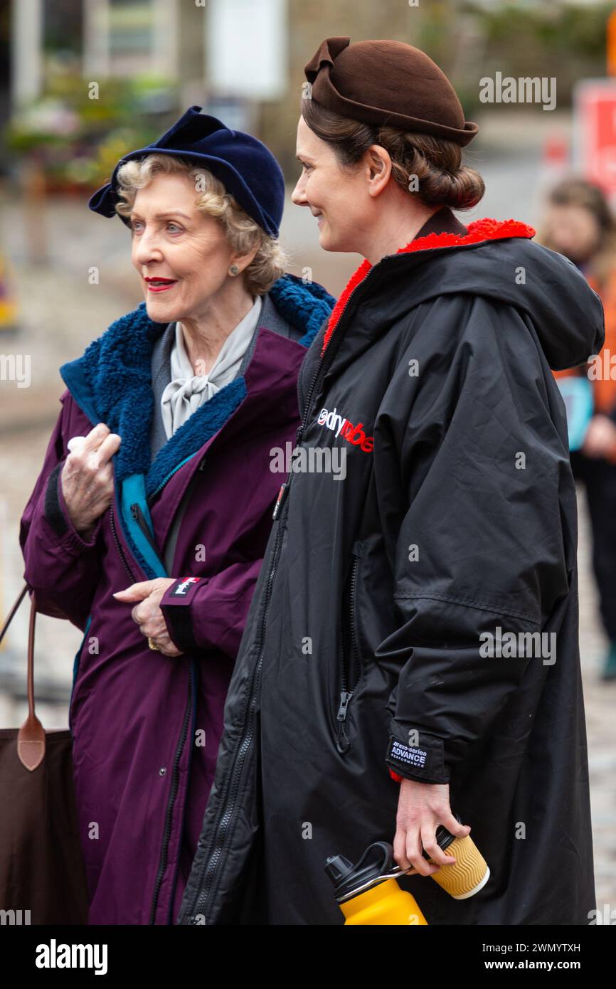 Grassington, Yorkshire, Regno Unito. 28 febbraio 2024. Le riprese della location iniziano per la quinta serie del popolare programma di Channel 5 e della PBS All Creatures Great & Small. Il cast e la troupe sono stati avvistati per le strade della piccola cittadina di Grassington, nello Yorkshire Dales, che viene convertita, due volte l'anno, nella città immaginaria di Darrowby. Nella foto Anna Madeley (Mrs Audrey Hall) e Patricia Hodge (Mrs. Pumphrey) arrivano sul set per filmare una scena al chiuso. Credito: Tom Holmes Photography / Alamy Live News). Foto Stock