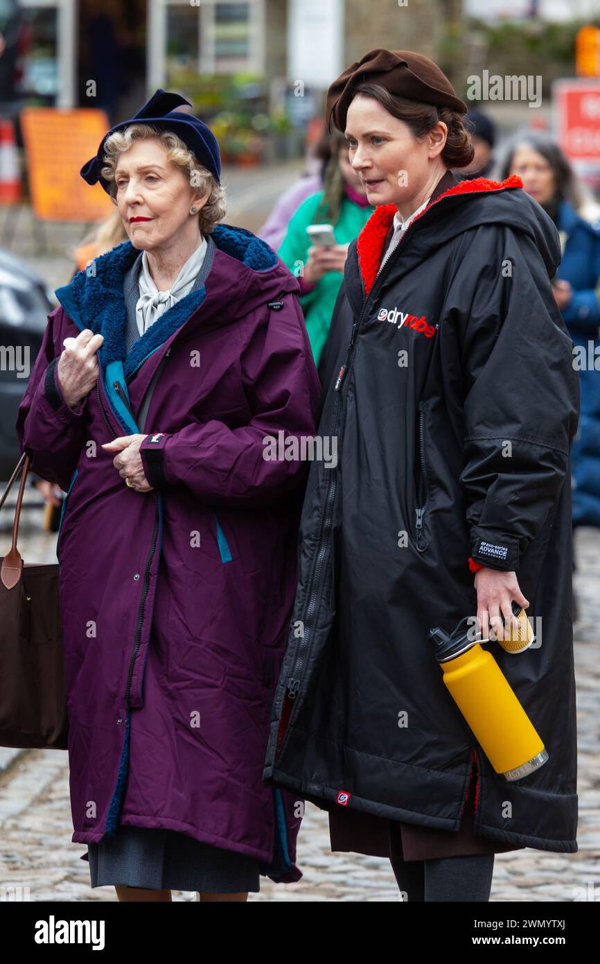 Grassington, Yorkshire, Regno Unito. 28 febbraio 2024. Le riprese della location iniziano per la quinta serie del popolare programma di Channel 5 e della PBS All Creatures Great & Small. Il cast e la troupe sono stati avvistati per le strade della piccola cittadina di Grassington, nello Yorkshire Dales, che viene convertita, due volte l'anno, nella città immaginaria di Darrowby. Nella foto Anna Madeley (Mrs Audrey Hall) e Patricia Hodge (Mrs. Pumphrey) arrivano sul set per filmare una scena al chiuso. Credito: Tom Holmes Photography / Alamy Live News). Foto Stock
