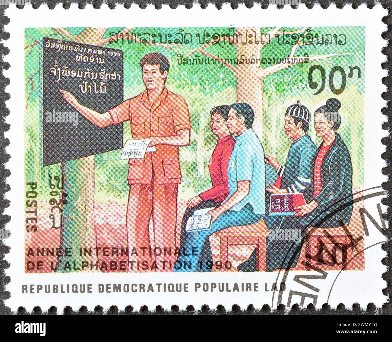 Francobollo cancellato stampato dal Laos, che mostra Educazione per adulti, anno internazionale dell'analfabetismo, circa 1990. Foto Stock