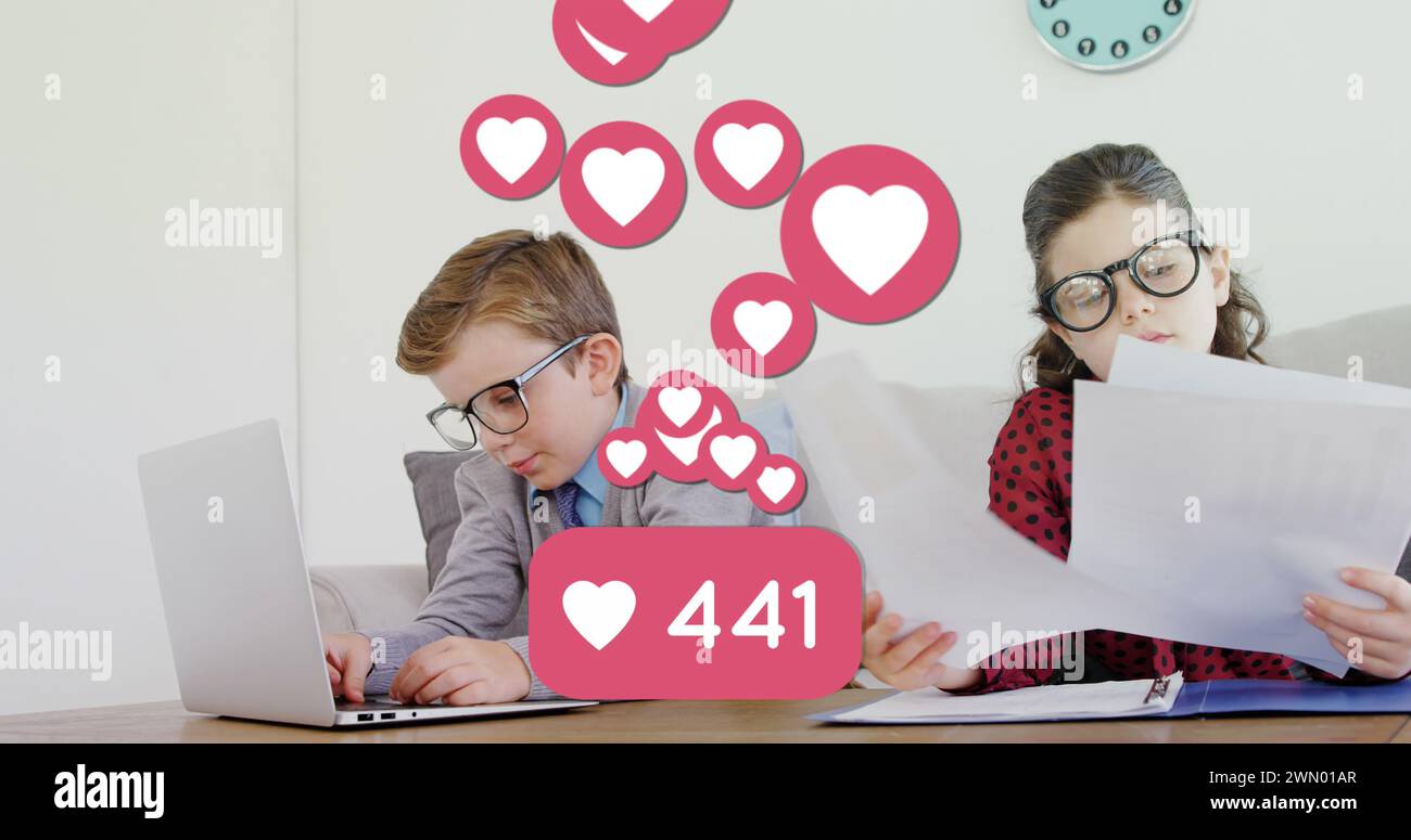 Gli scolari collaborano in un ufficio, circondati da icone d'amore digitali, che simboleggiano i social media. Foto Stock