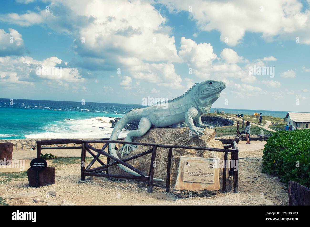 ISLA MUJERES, MESSICO - 20 febbraio 2016: Statua di una grande iguana dalla coda spinosa nera a Punta Sur, isola di Isla Mujeres con il Mar dei Caraibi sullo sfondo. Foto Stock