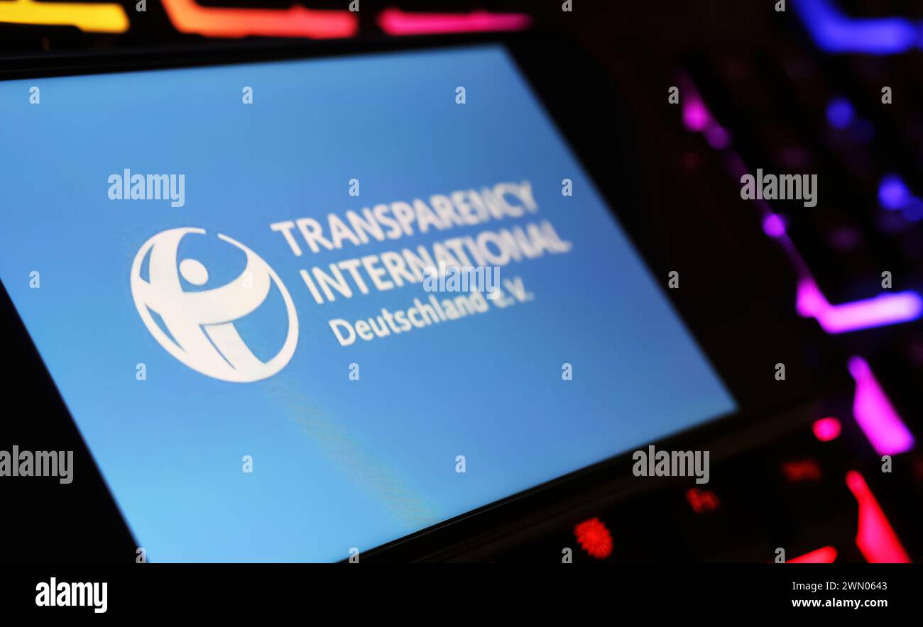 Viersen, Germania - 9 gennaio. 2024: Schermo dello smartphone con logo di Transparency International sulla tastiera del computer Foto Stock