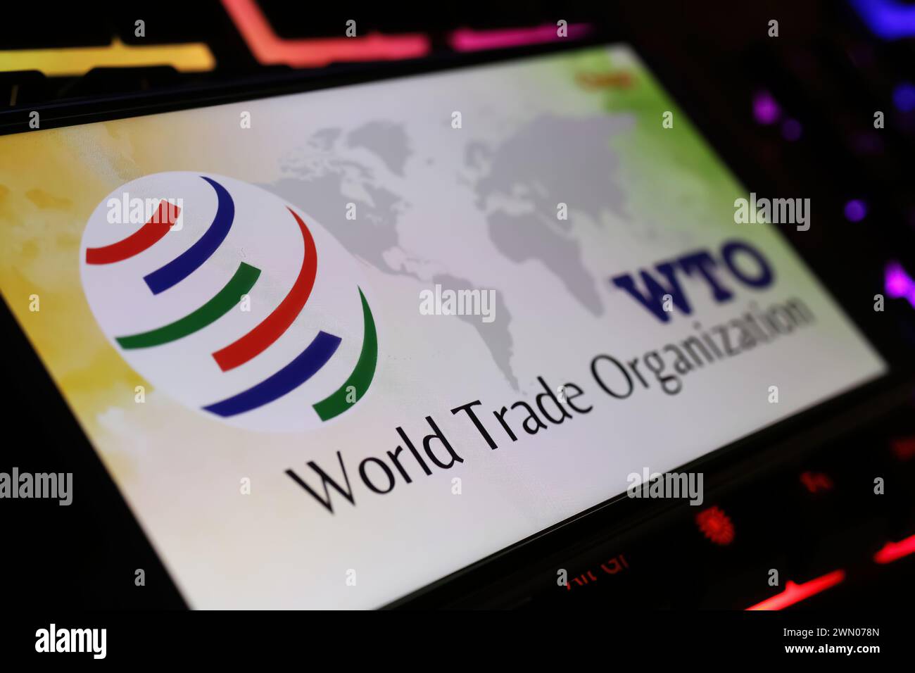 Viersen, Germania - 9 gennaio. 2024: Schermo smartphone con logo dell'organizzazione mondiale del commercio OMC sulla tastiera del computer Foto Stock