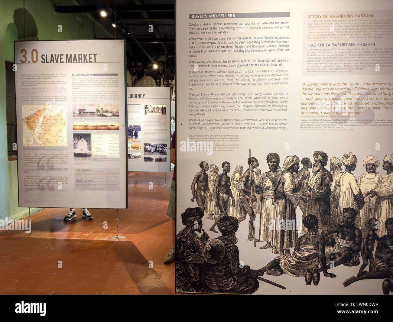 Una donna turistica occidentale guarda una mostra nella East Africa Slave Trade Exhibition, Stone Town, Zanzibar, Tanzania Foto Stock