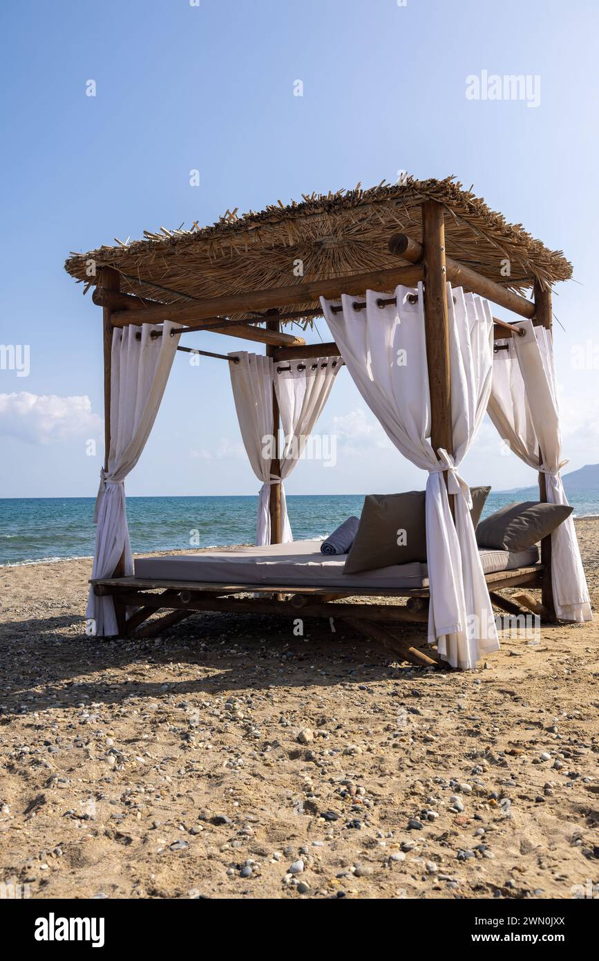 Creta sulla spiaggia con lettino, tipico tetto e mare Foto Stock