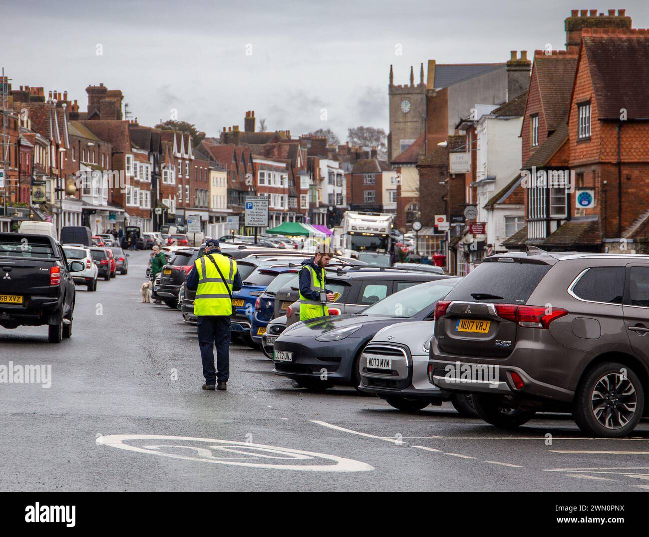 I guardiani del traffico pattugliano la trafficata strada nella città storica di Marlborough Wiltshire, fiancheggiata da automobili e architettura tradizionale. Foto Stock