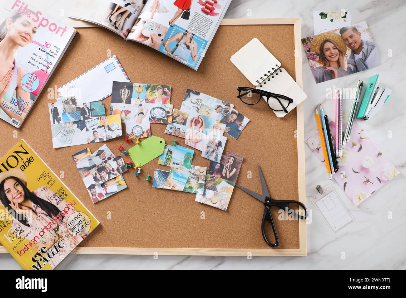 Composizione piatta con diverse foto, riviste e cancelleria su sfondo in marmo bianco. Creazione della bacheca di visione Foto Stock