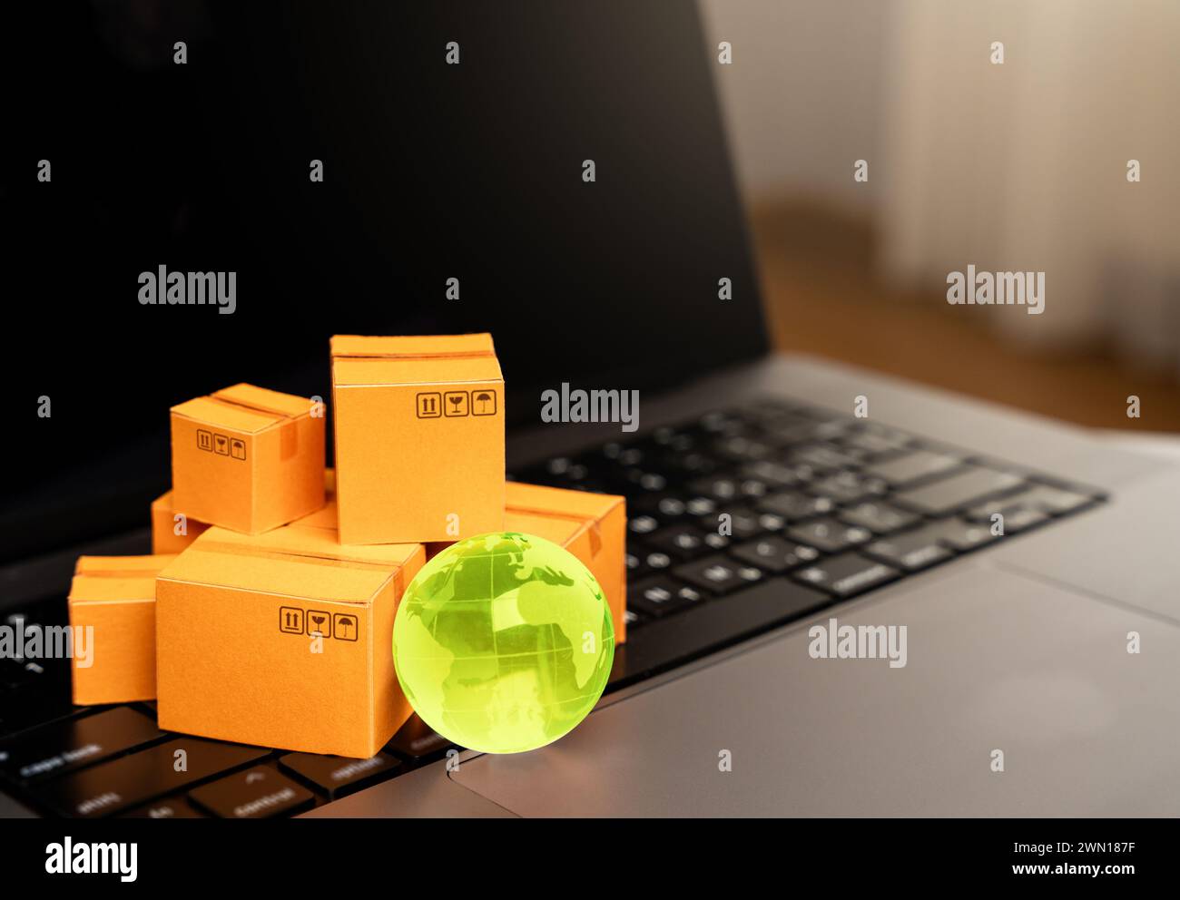 Scatole con articoli e un computer portatile. Produzione di contenitori. Importazione o esportazione. Registrazione delle consegne e del trasporto con gli operatori del trasporto marittimo. Foto Stock