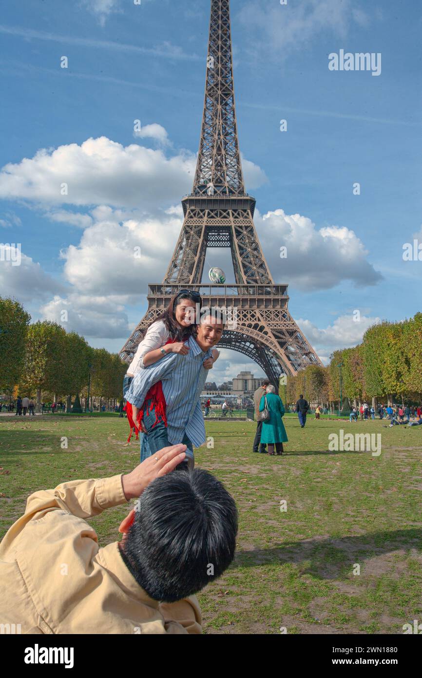 Torre Eiffel con il turista cinese che si diverte a posare per le foto, Parigi Francia Foto Stock