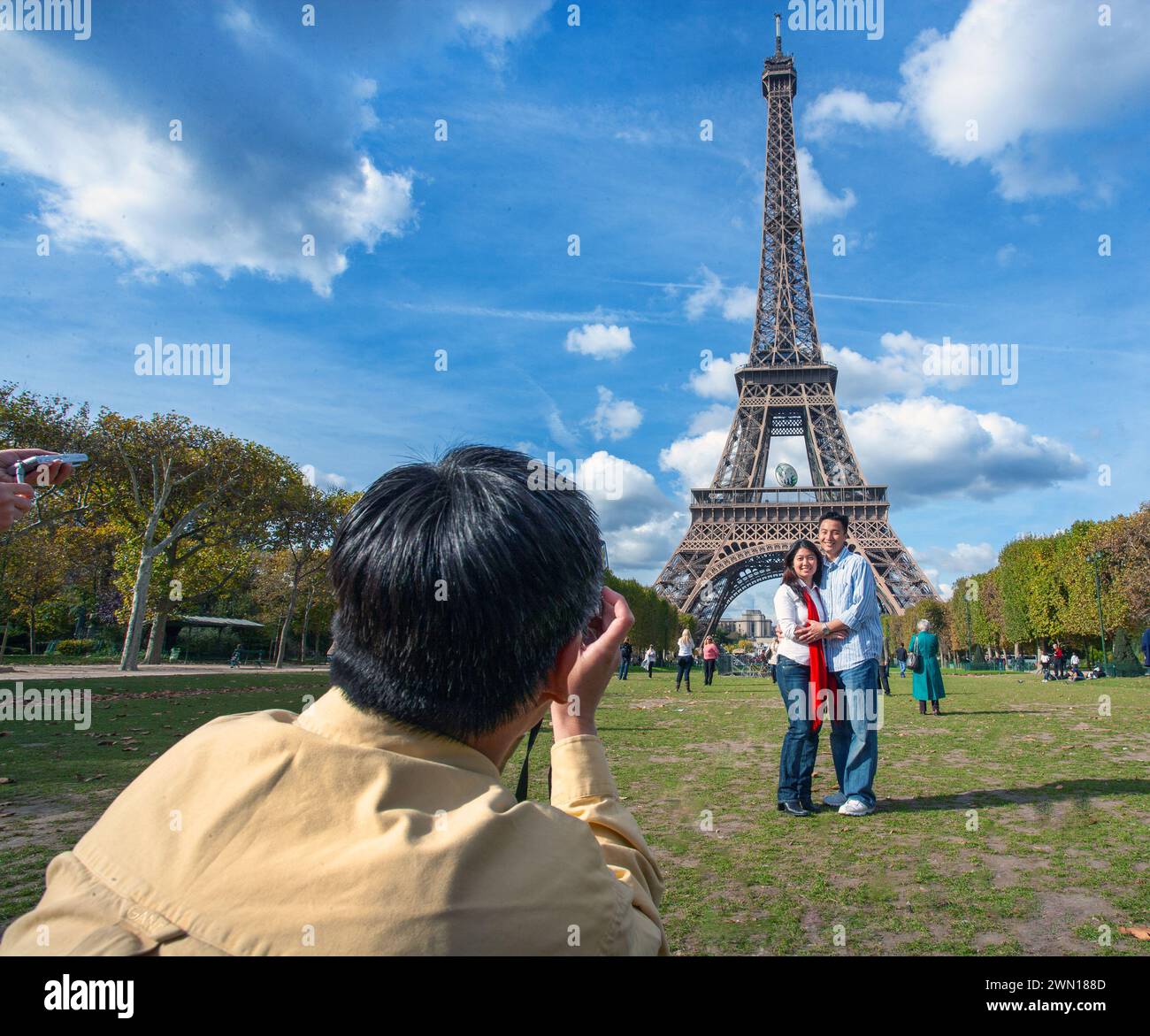 Torre Eiffel con il turista cinese che si diverte a posare per le foto, Parigi Francia Foto Stock
