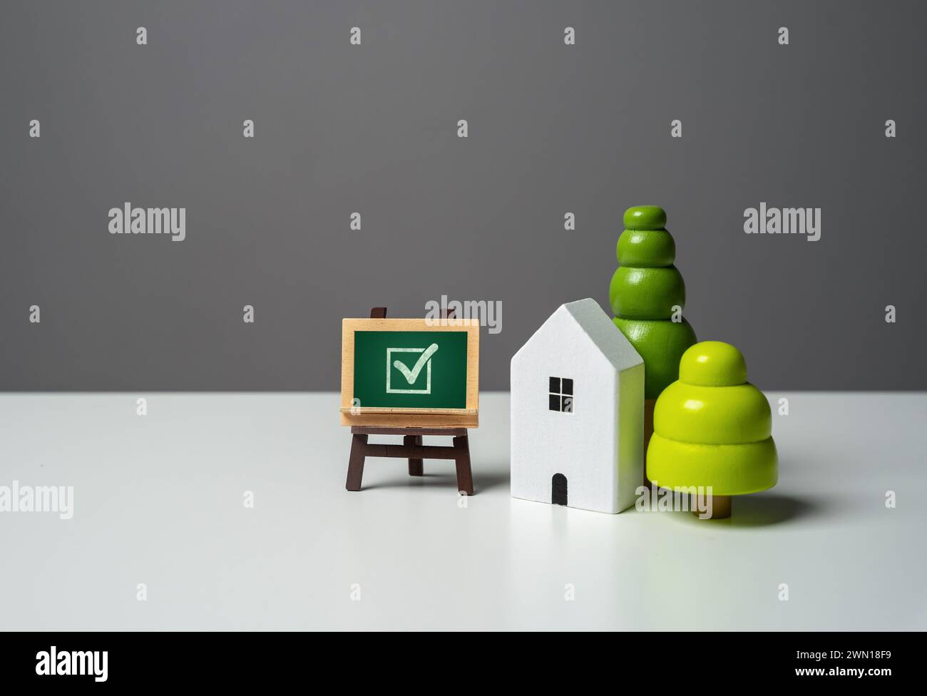 E firma con un segno di spunta. Conformità degli alloggi ai criteri e alle norme di qualità necessari. Cerca un buon immobile da comprare. Agente immobiliare Foto Stock