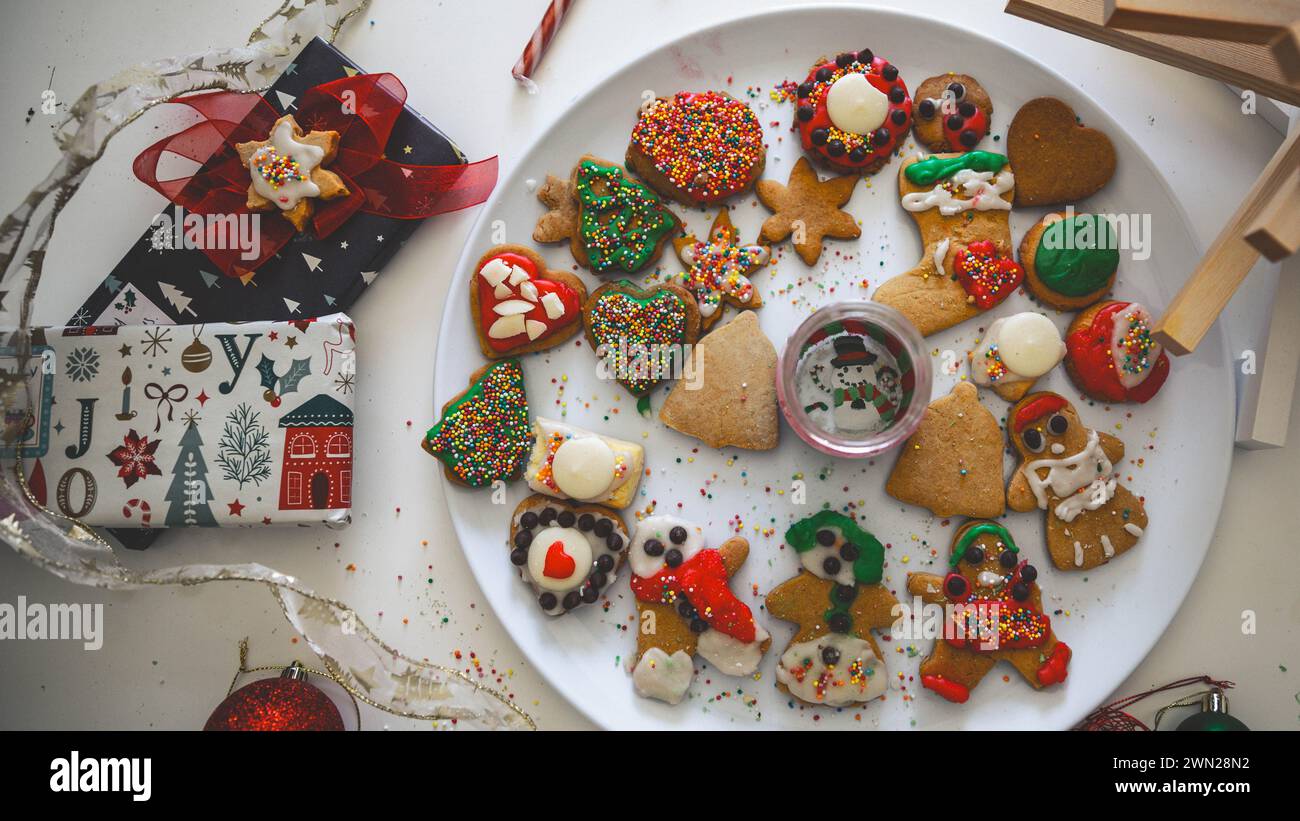 Magia natalizia e felicità fatta in casa: Uomini e donne di pan di zenzero cotti e ghiacciati insieme come una tradizione festiva nello spirito delle feste. Foto Stock