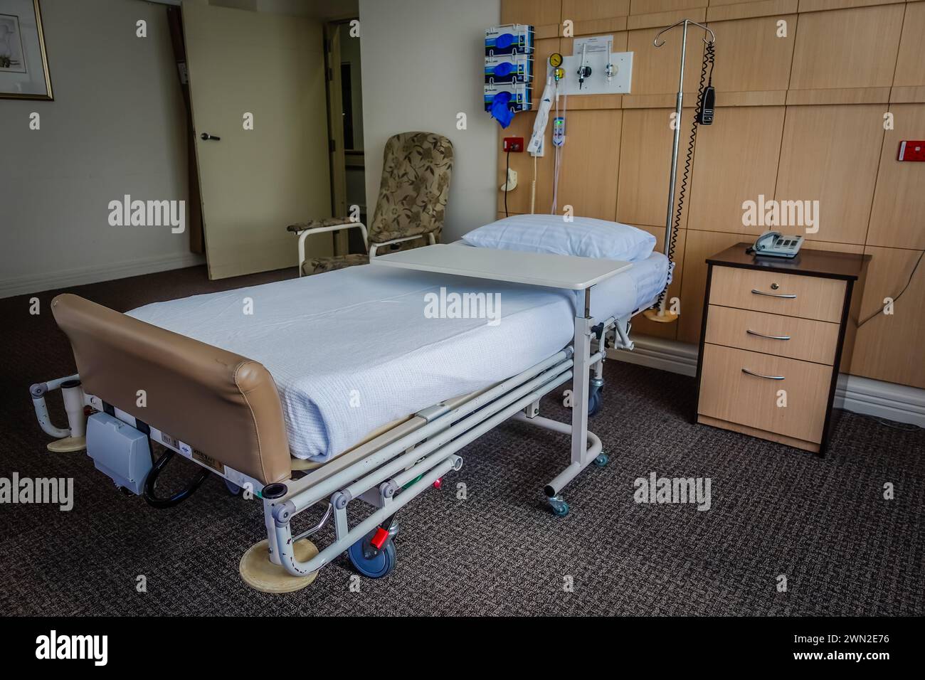 Una stanza privata vuota per i pazienti all'interno di un ospedale in Australia, dotata di un comodo letto, attrezzature mediche e servizi per la comodità dei pazienti Foto Stock