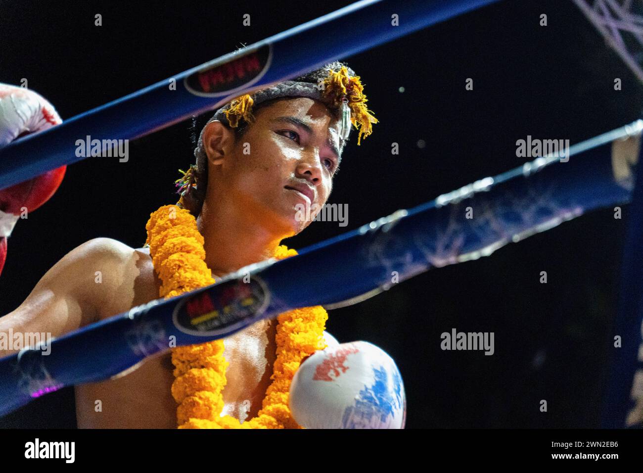 Koh Chang, Thailandia. 24 febbraio 2024. Boxer Petch Wan Den, indossando un tradizionale archetto Mongkon e una collana di ghirlande di fiori, esegue Wai Khru, la cerimonia rituale prima di una lotta allo spettacolo settimanale Muay Thai Fights a Koh Chang. Petch Wan Den ha sconfitto Liem Petch. Credito: SOPA Images Limited/Alamy Live News Foto Stock