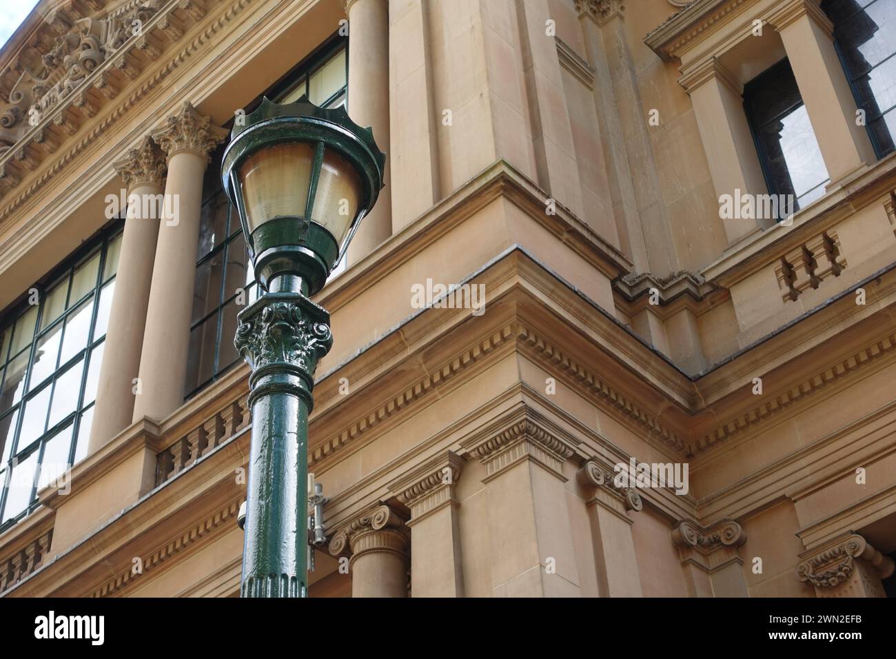 Vista ravvicinata di un lampione verde presso il Municipio di Sydney, che mostra il suo design intricato e l'estetica vintage sullo sfondo della storica città Foto Stock