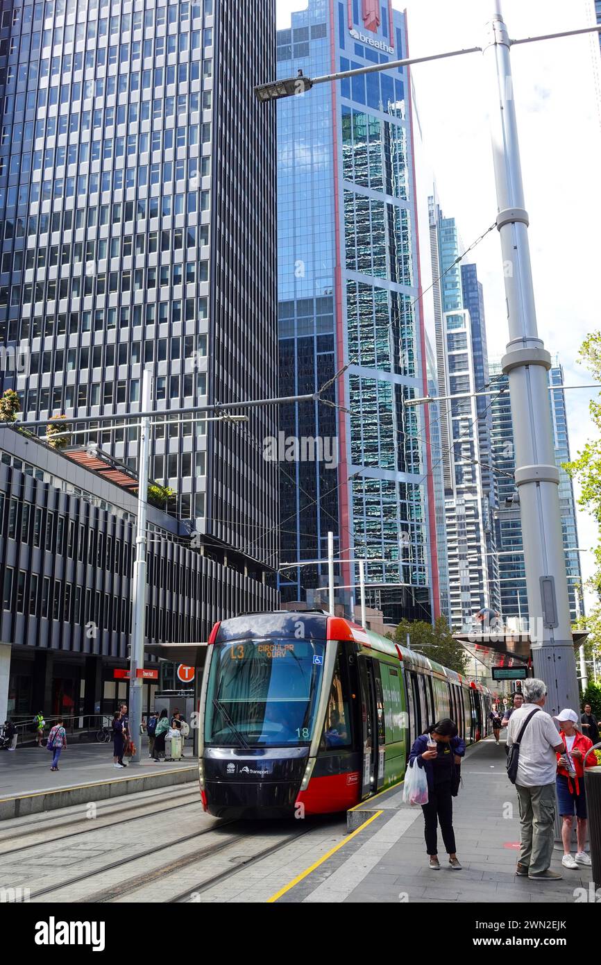Un treno della Sydney Light Rail che esce da una stazione di George Street a Sydney in una giornata di sole, catturando la scena urbana e l'attività dei trasporti in Foto Stock