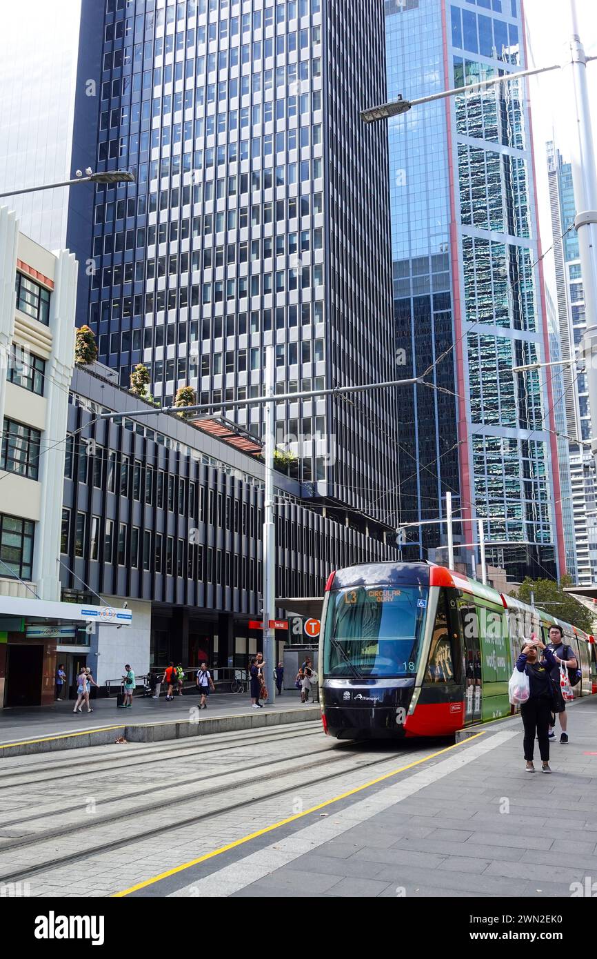 Un treno della Sydney Light Rail che esce da una stazione di George Street a Sydney in una giornata di sole, catturando la scena urbana e l'attività dei trasporti in Foto Stock