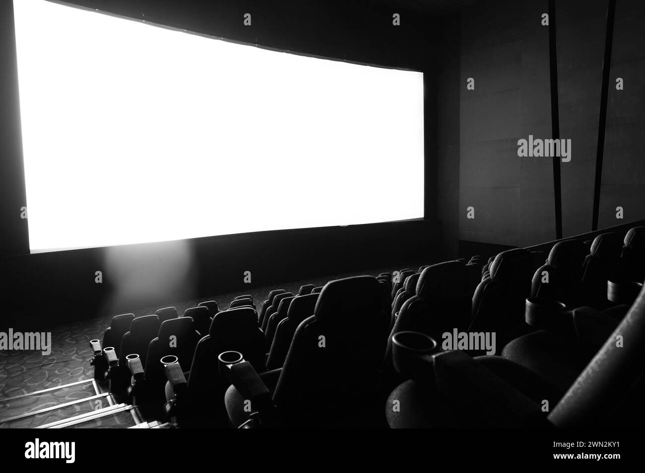 Interni scuri del cinema con schermo e sedie Foto Stock