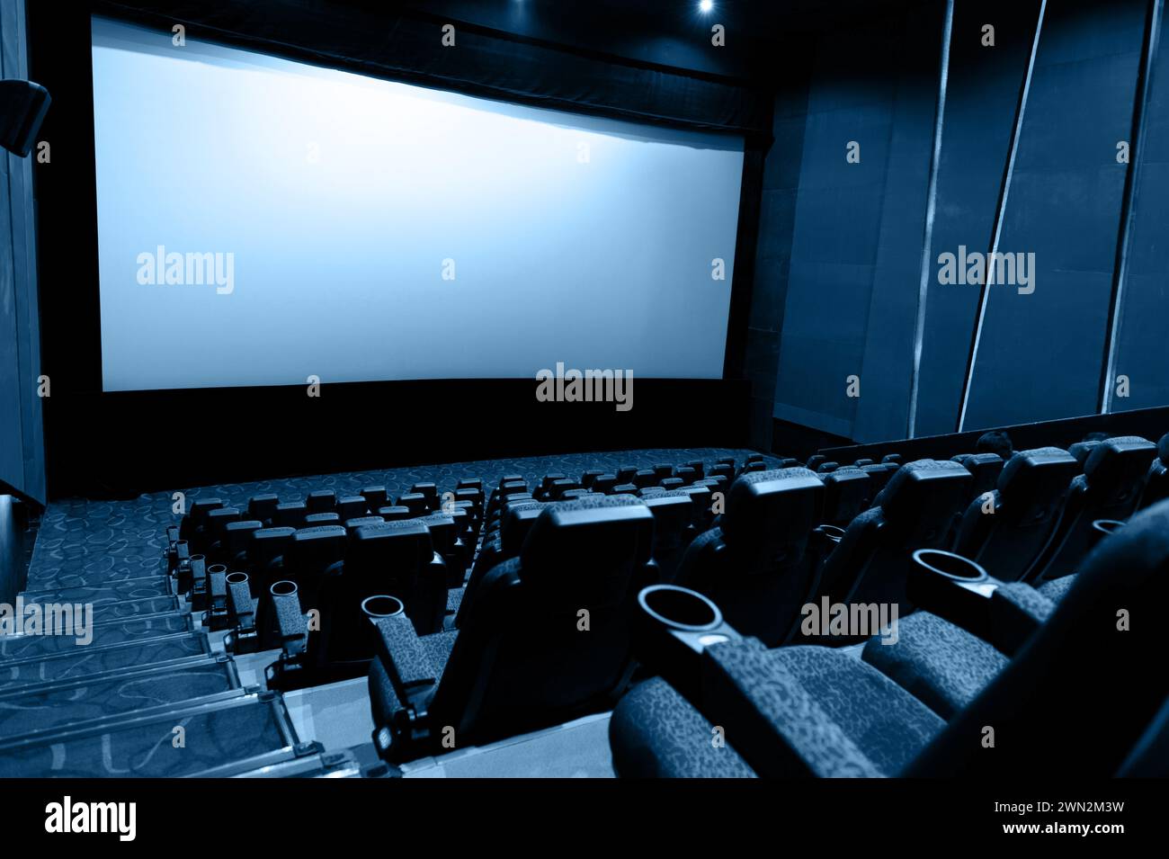 Interni scuri del cinema con schermo e sedie Foto Stock