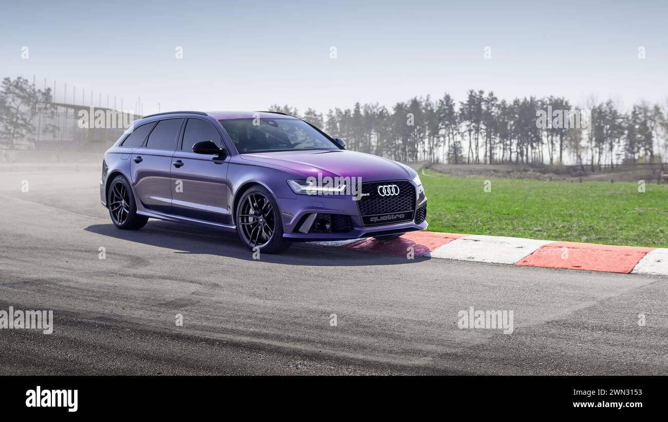 Merlin Purple Audi RS6 sull'anello Chayka. Vista anteriore di tre quarti della versione Performance dell'Audi A6 Avant (generazione C6) su un marciapiede alla svolta a sinistra. Foto Stock