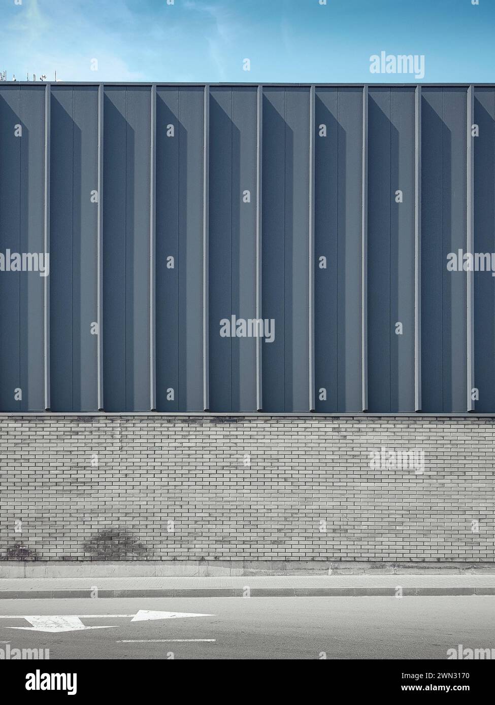 Muro del moderno edificio grigio in una giornata di sole. Facciata con elementi decorativi verticali ad alette. Foto Stock