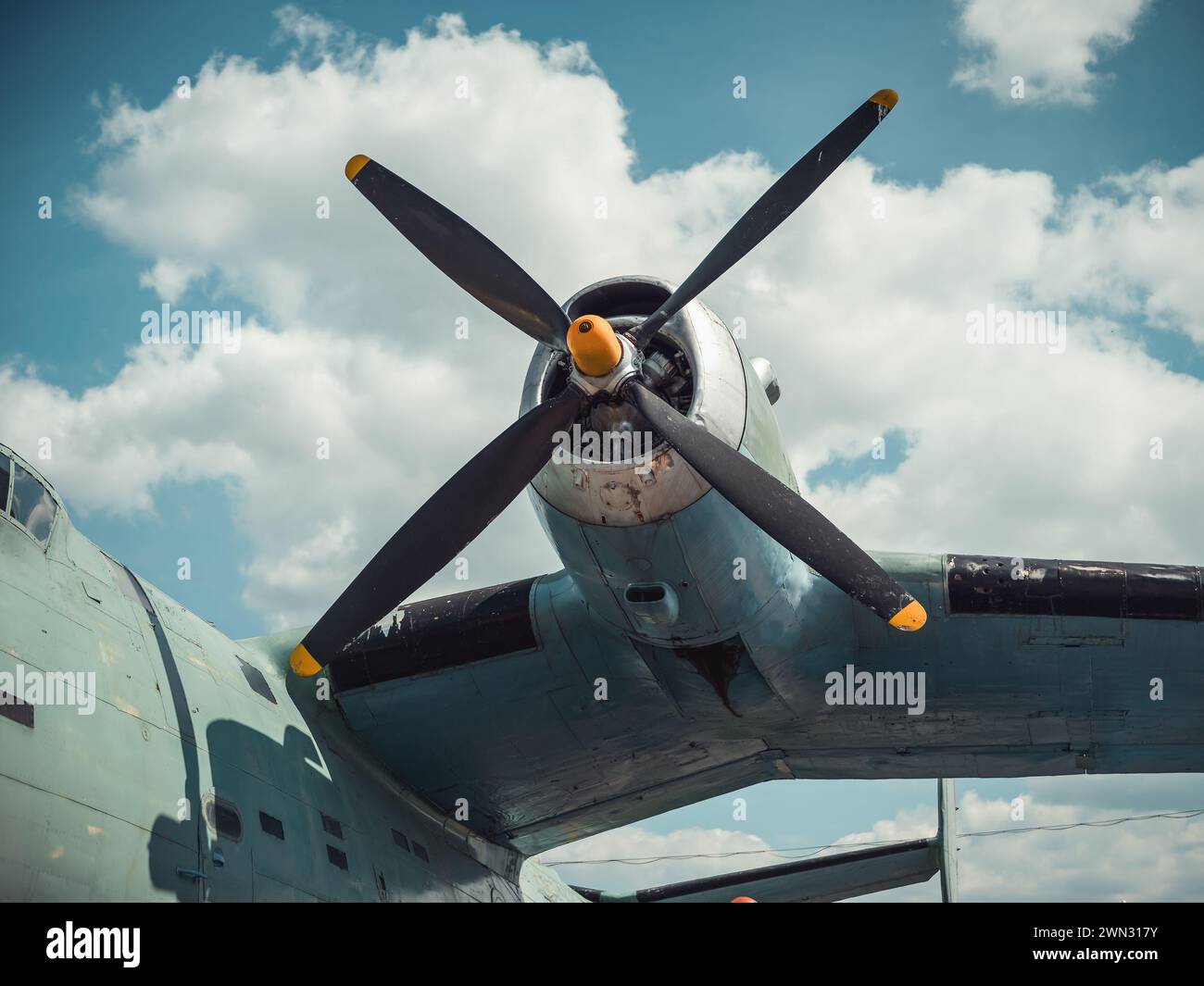 Elica e ala di un vecchio aereo davanti al cielo nuvoloso. Vista ravvicinata di un aereo d'epoca con ali di gabbiano verde verde acqua degli anni '1950. Aviazione d'epoca. Foto Stock