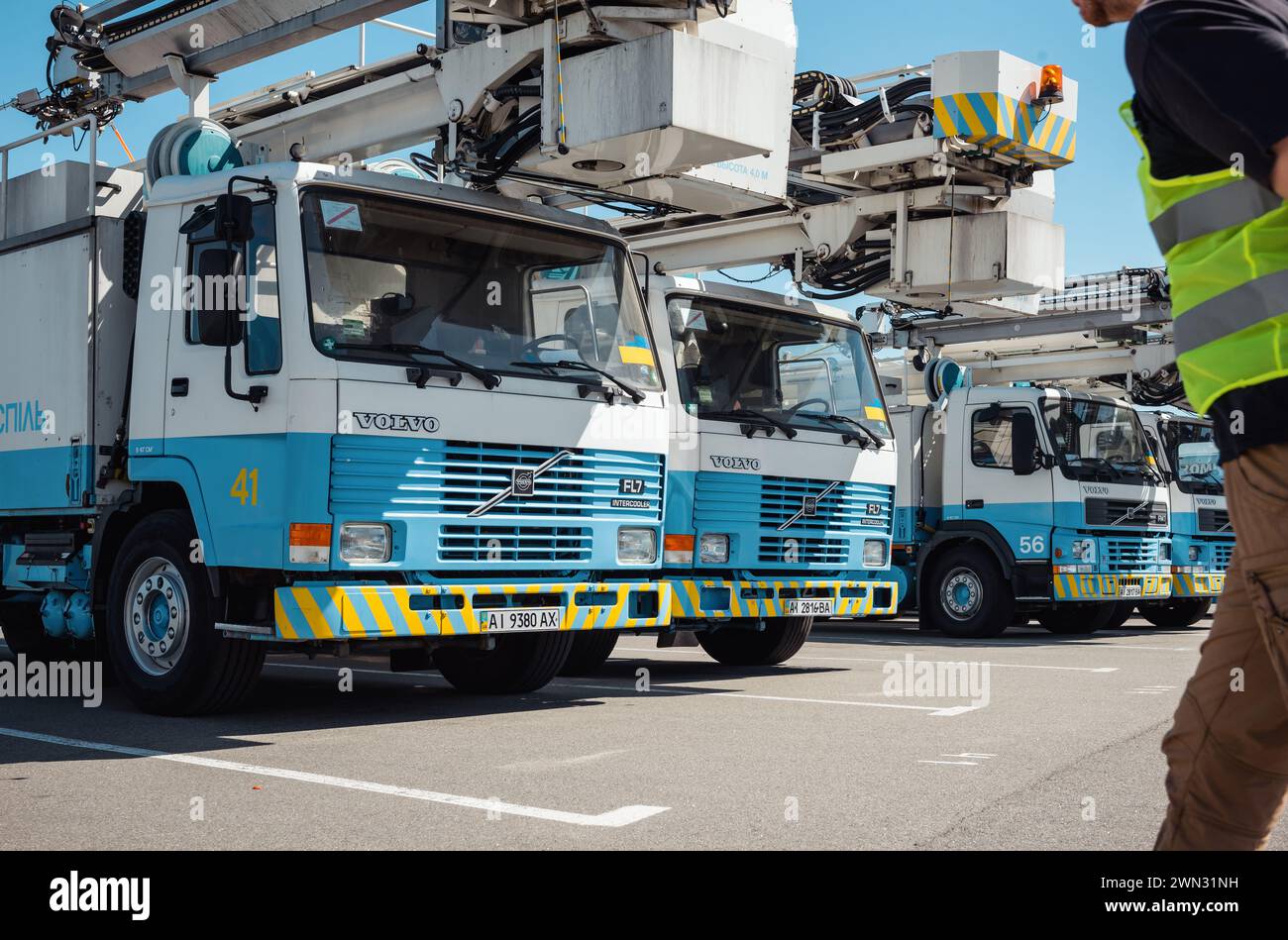 una fila di carrelli per lo sbrinamento nell'aeroporto. Pochi camion Volvo per la manutenzione hanno parcheggiato in fila al piazzale dell'aeroporto di Boryspil. Foto Stock