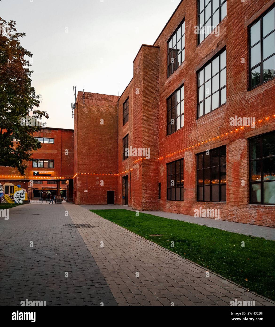 edificio loft a 3 piani con facciata in mattoni. Cortile interno di una vecchia fabbrica, ora rivitalizzata come centro culturale e spazi per uffici. Foto Stock