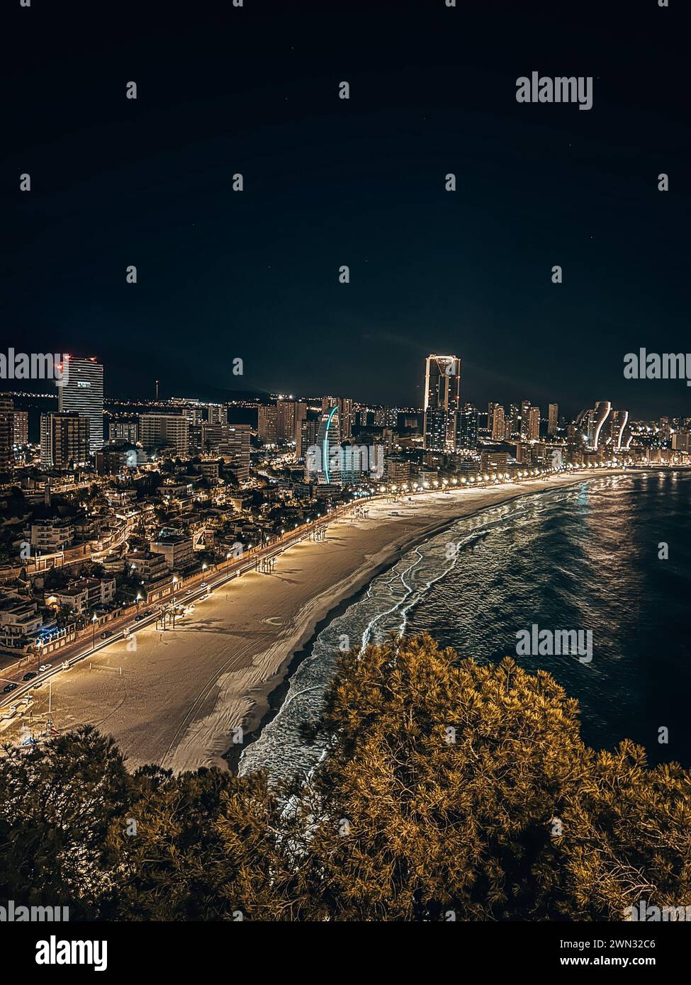 La costa di Benidorm con edifici illuminati di notte. Spagna Foto Stock