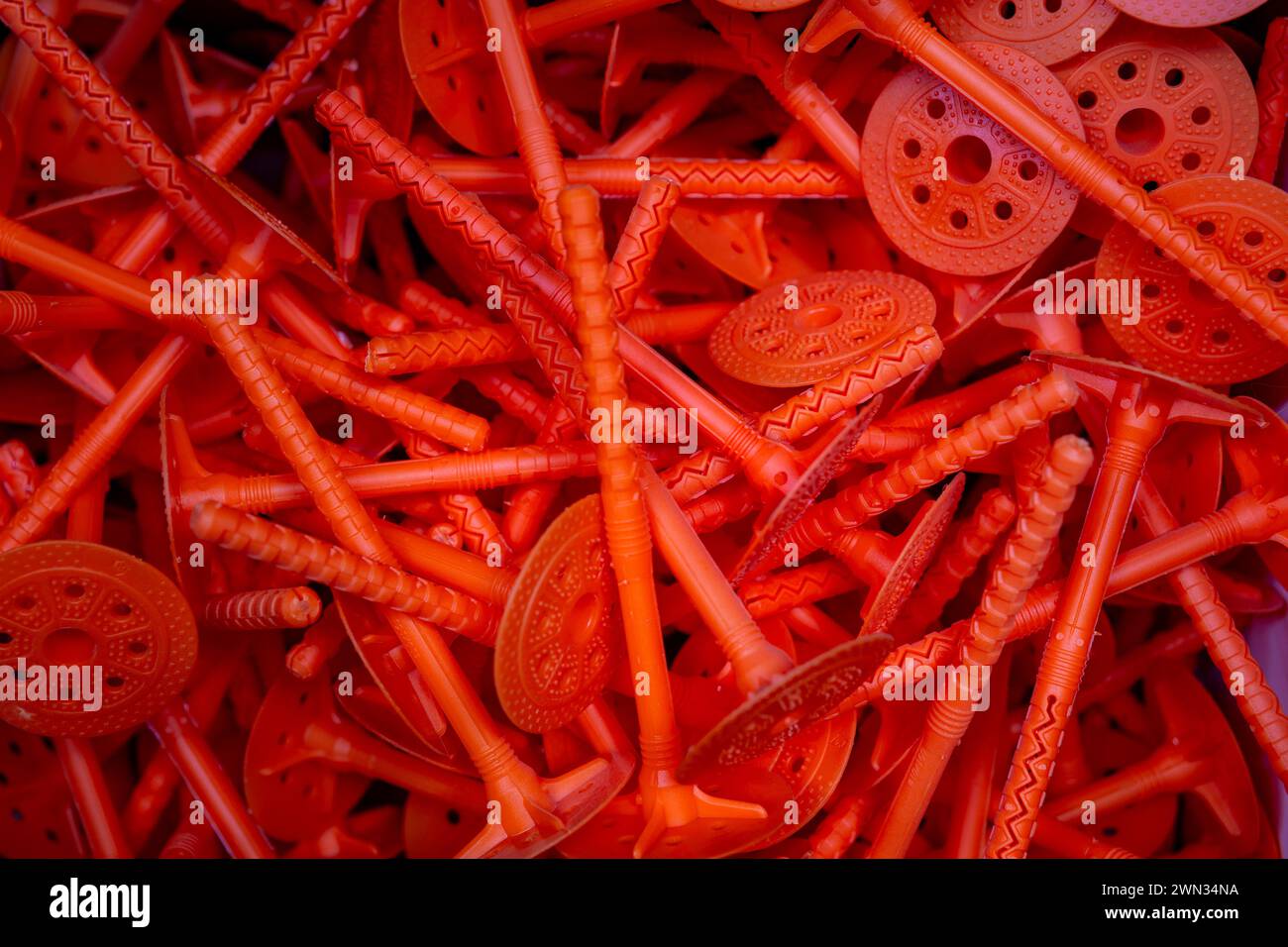 Sfondo con supporti in plastica per isolamento termico. Tassello "fungo" - il nome del dispositivo di fissaggio: Tassello per isolamento termico, tassello a disco, ombrello Foto Stock