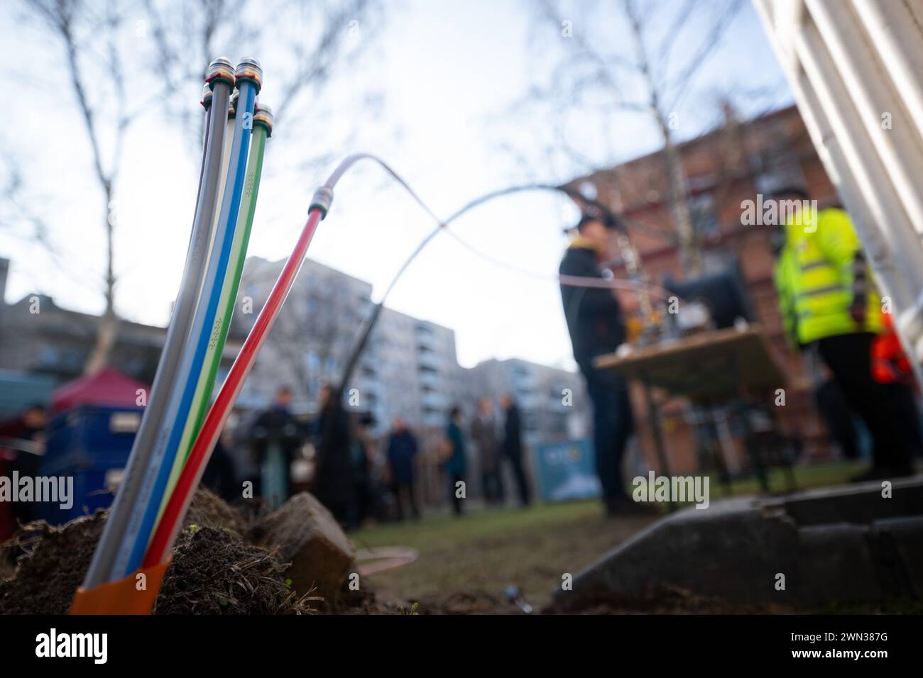 Berlino, Germania. 29 febbraio 2024. I condotti vuoti per cavi in fibra ottica sporgono da una fossa durante una dimostrazione della posa di cavi in fibra ottica in un cantiere della cooperativa edilizia di Charlottenburg. Berlino mira ad avere 2,2 milioni di famiglie e aziende collegate alla rete in fibra ottica entro il 2028. Crediti: Sebastian Christoph Gollnow/dpa/Alamy Live News Foto Stock