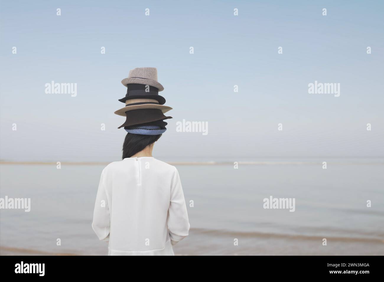 la donna surreale da dietro indossa innumerevoli cappelli sulla testa, concetto astratto Foto Stock