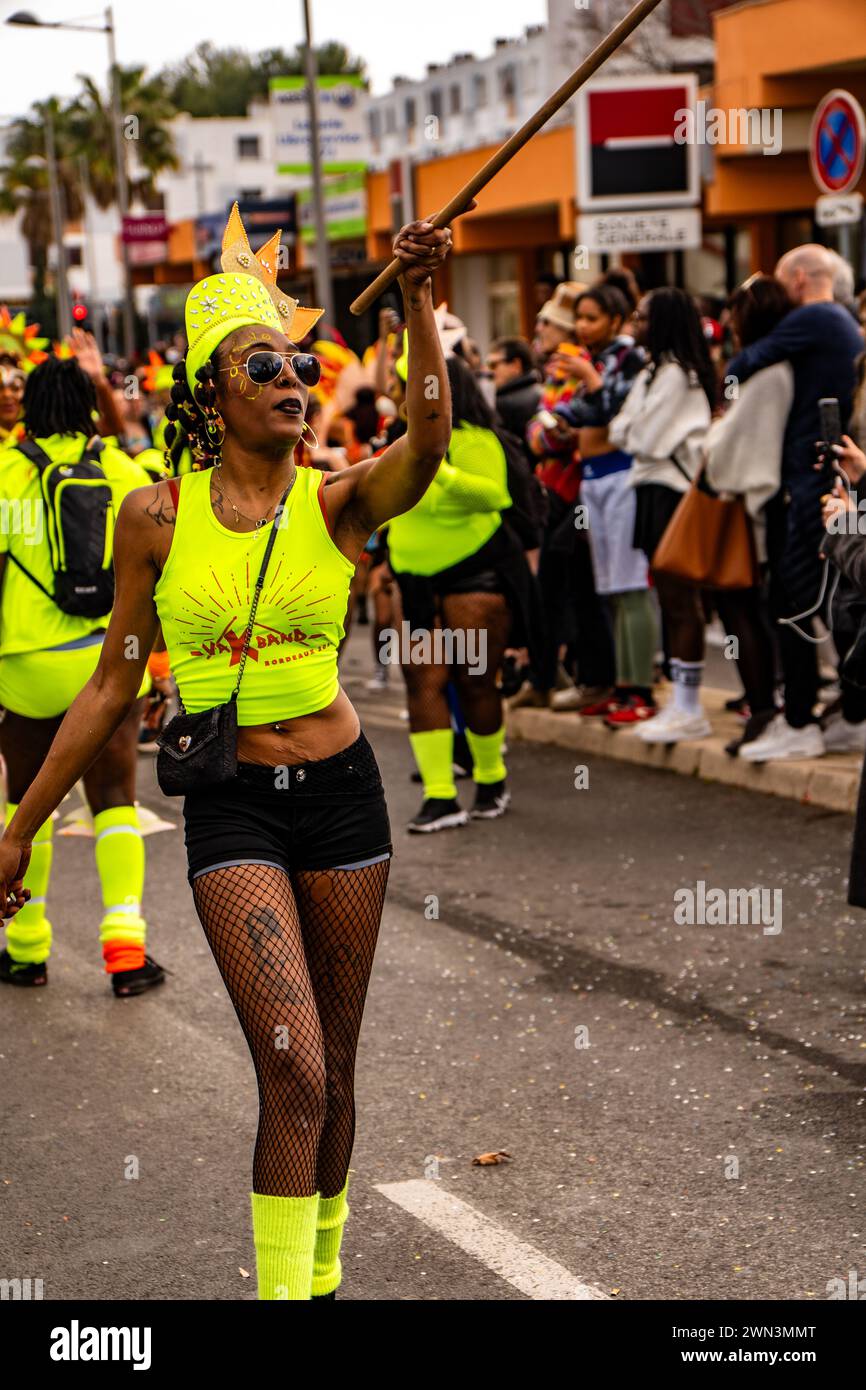 Un gruppo di individui che indossano magliette gialle e verdi neon sfilano su una strada della città, il Carnevale di Montpellier Foto Stock
