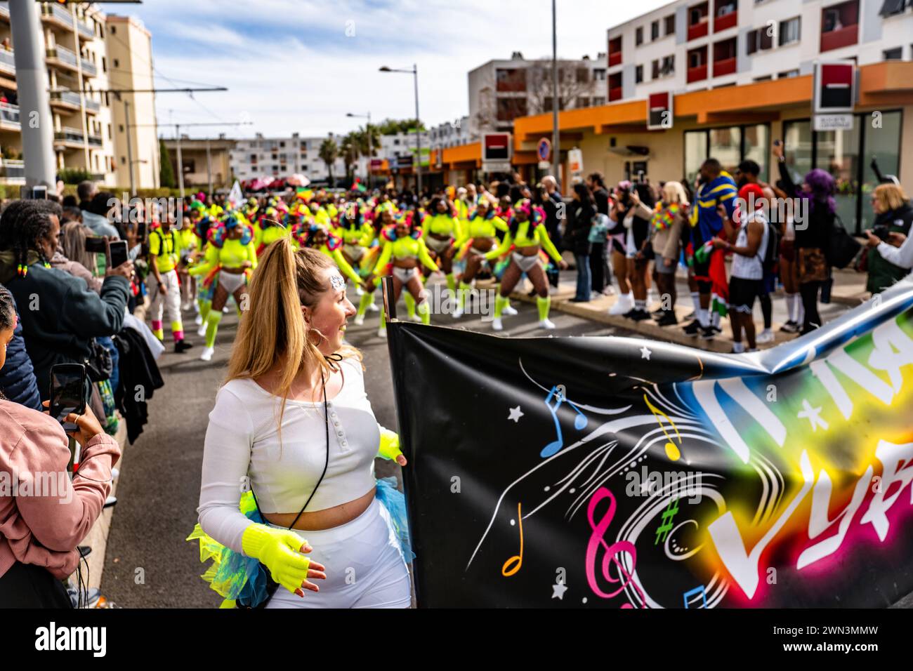 Una donna passeggia attraverso una strada trafficata tra una folla di persone, il Carnevale di Montpellier Foto Stock