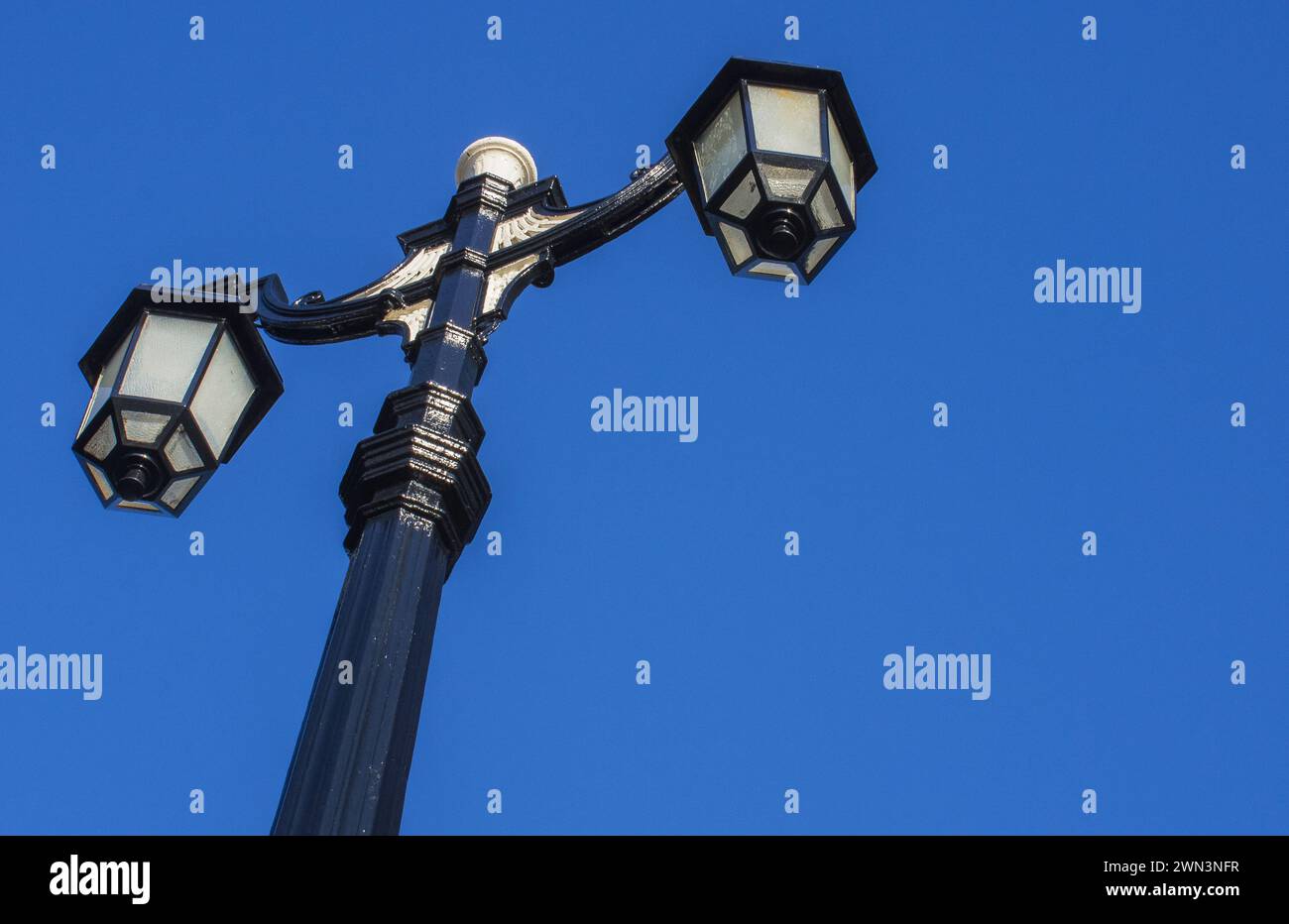 Illuminazione stradale in vecchio stile con doppie lampade contro il cielo blu Foto Stock