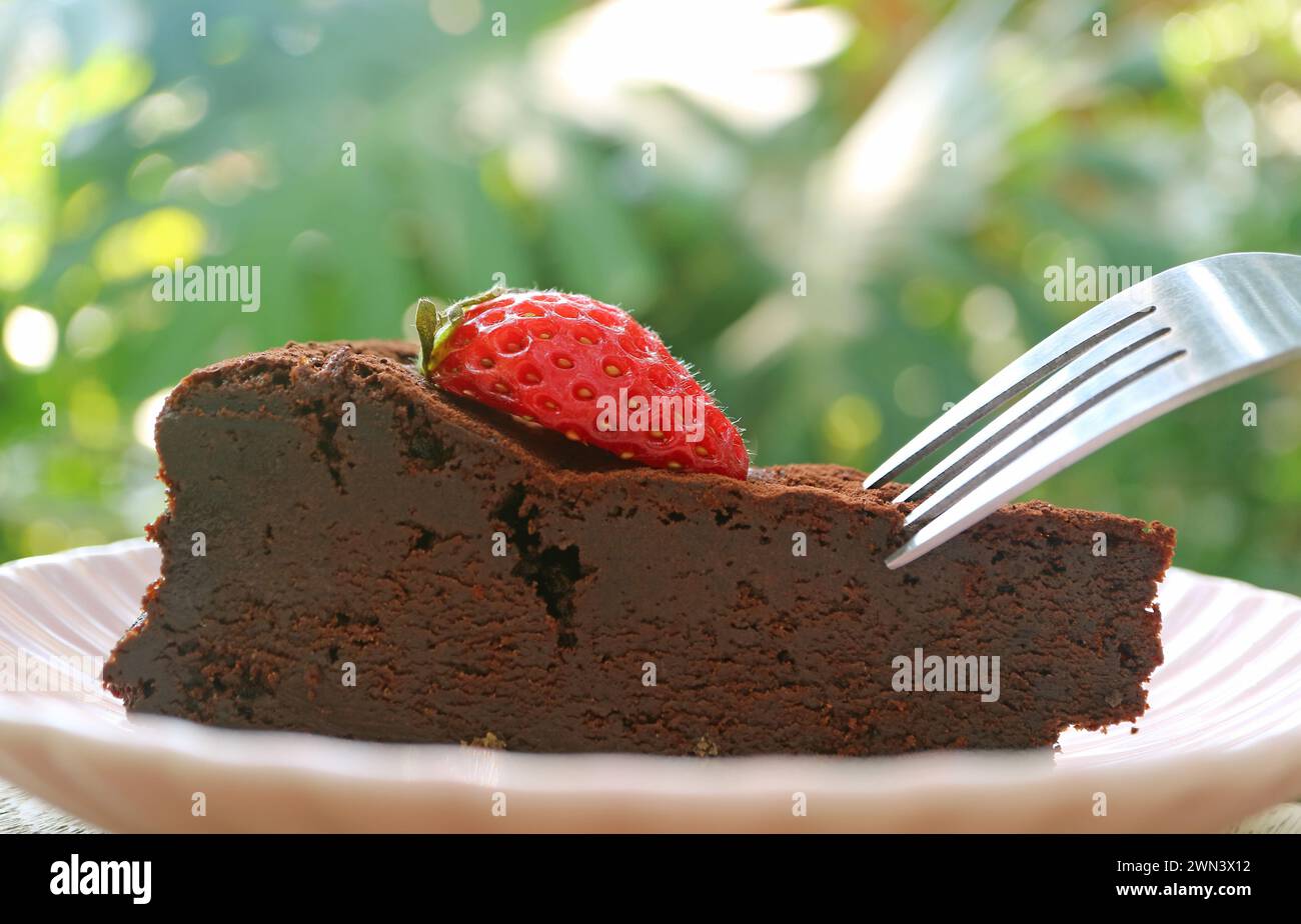 Primo piano della torta al cioccolato senza fiori umida e saporita con fragola fresca Foto Stock