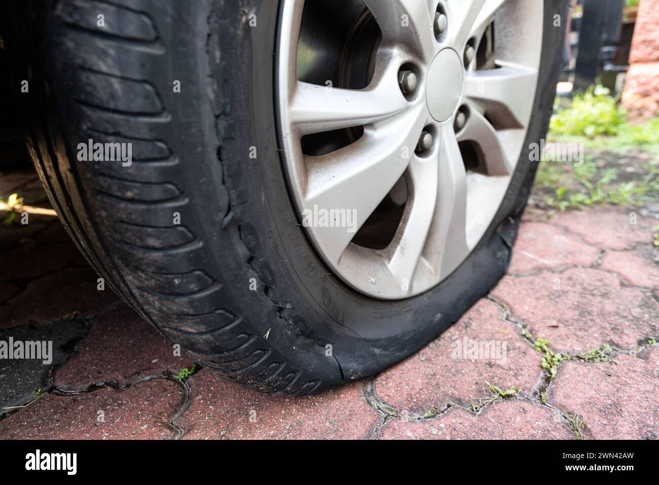 Primo piano dello pneumatico sgonfio per auto a causa della rottura sul lato della ruota Foto Stock