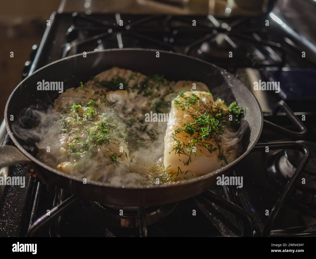 Il merluzzo nella padella viene cotto nella padella calda Foto Stock