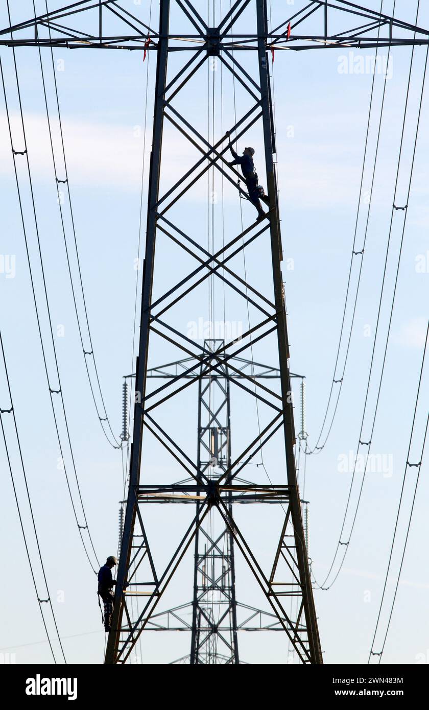 29/11/12 operai dipingono oggi piloni elettrici ad alta tensione nei pressi di Alderley Edge, Cheshire. Nonostante le torri di metallo ghiacciate siano congelate Foto Stock